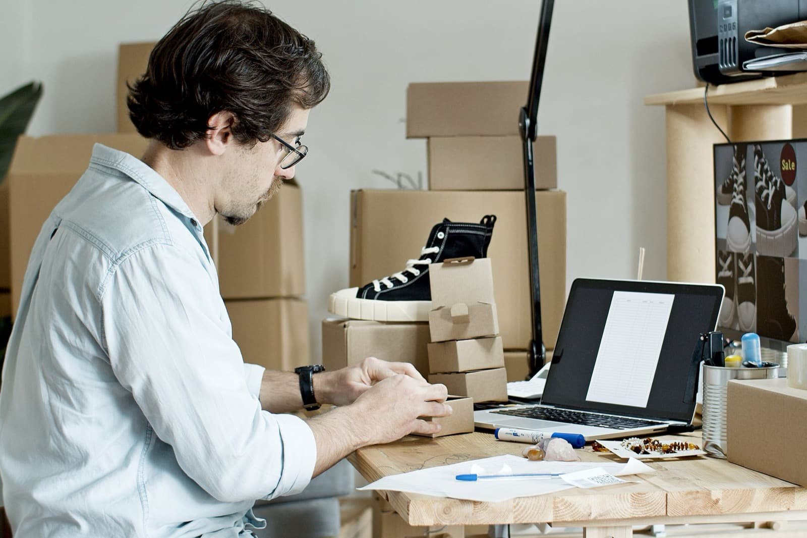 Vendeur en ligne préparant ses commandes devant son ordinateur